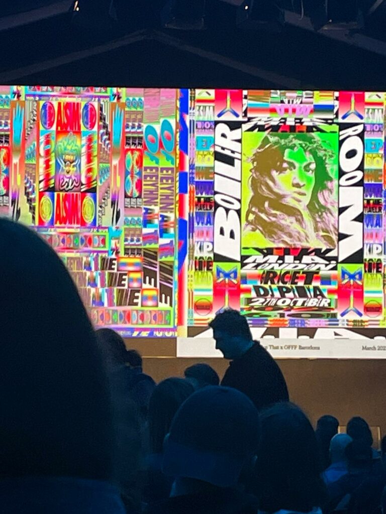 Photo of a colorful graphic over the shoulders of a crowd at a presentation